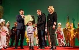 Zdjęcie przedstawia Prezydenta Miasta Ostrowca Świętokrzyskiego Jarosława G&oacute;rczyńskiego przekazującego nagrodę zwycięzcom konkursu podczas Wielkanocnego Ryneczku 2022