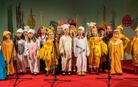 Zdjęcie przedstawia dzieci śpiewające w przebraniach kurczaczk&oacute;w na Wielkanocnym Ryneczku 2022