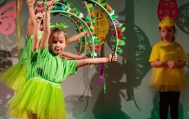 Zdjęcie przedstawia dzieci tańczące z rekwizytami na Wielkanocnym Ryneczku 2022