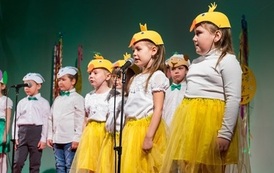 Zdjęcie przedstawia dzieci śpiewające w przebraniach kurczaczk&oacute;w na Wielkanocnym Ryneczku 2022