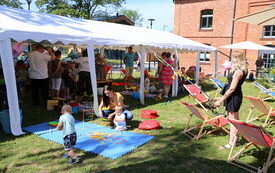 Uśmiechnięci uczestnicy podczas zabaw na dziedzińcu Ostrowieckiego Browaru Kultury