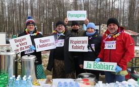 Osoby stoją z tabliczkami w ręku z napisanym tekstem