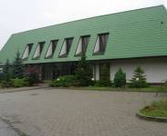budynek firmy Netia - biały budynek z zielonym dachem 